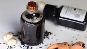 شیشه روغن سیاه دانه اصل در کنار یک بطری روغن سیاه دانه