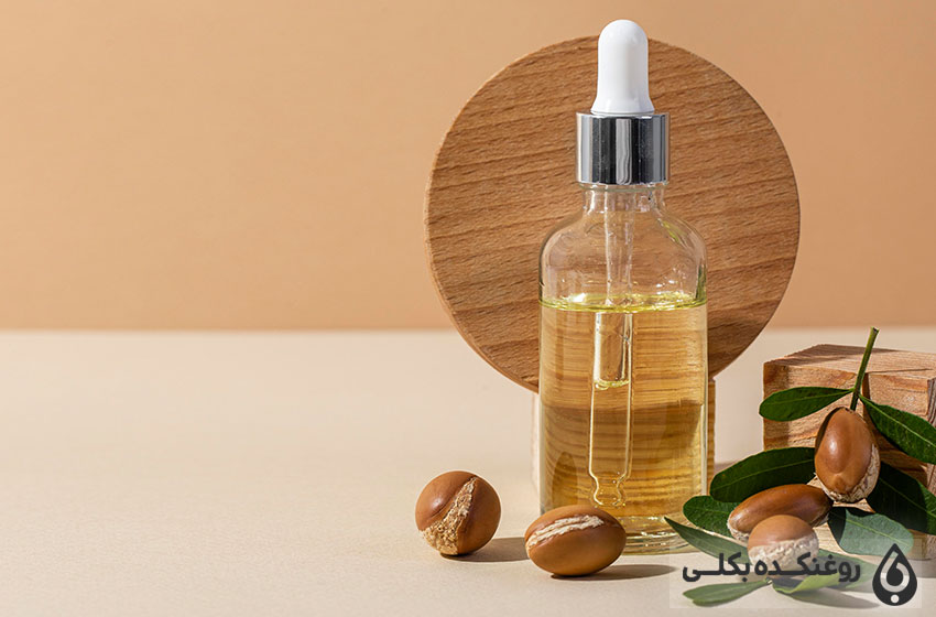 یک شیشه حاوی روغن آرگان و دانه های آرگان