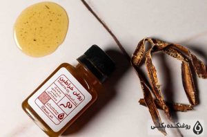 شیشه ای حاوی روغن خراطین، کرم خراطین و مقداری روغن ریخته