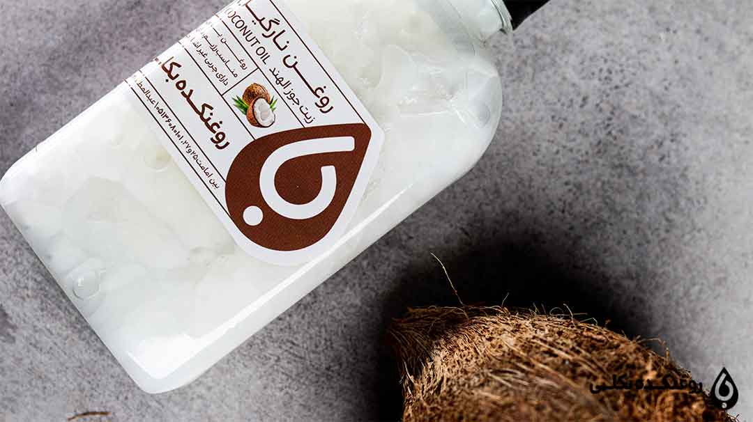 یک شیشه حاوی روغن نارگیل به همراه یک نارگیل