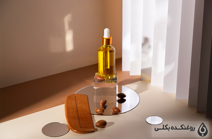یک شیشه حاوی روغن آرگان و دانه های آرگان و شانه