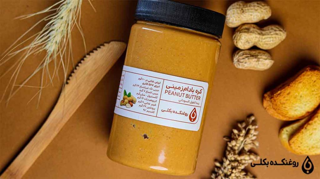 کره بادام زمینی در کنار تعدادی بادام زمینی