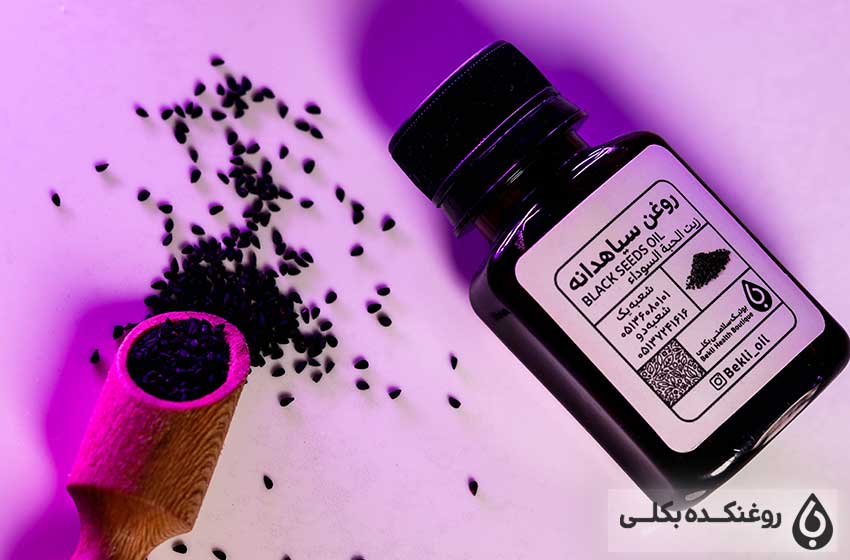 یک شیشه حاوی روغن سیاه دانه و دانه های سیاه دانه