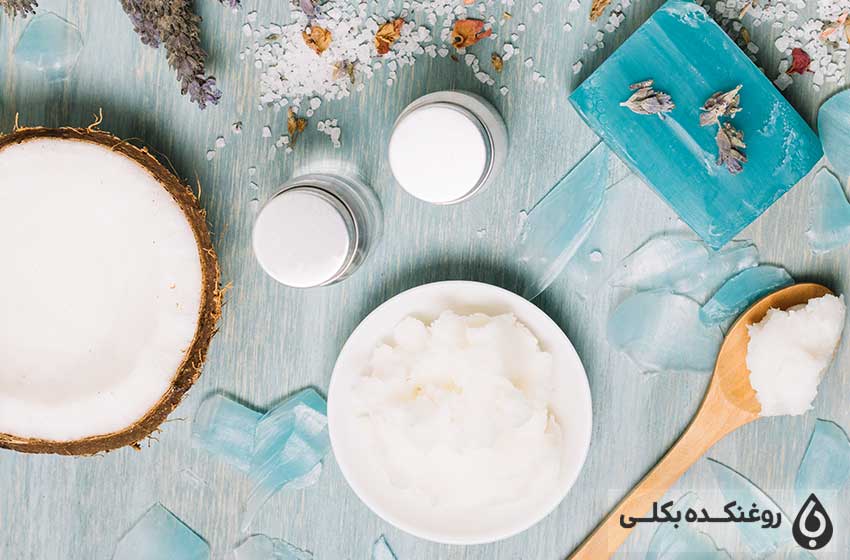 یک قاشق حاوی نارگیل یک تکه نارگیل و دو شیشه حاوی روغن نارگیل