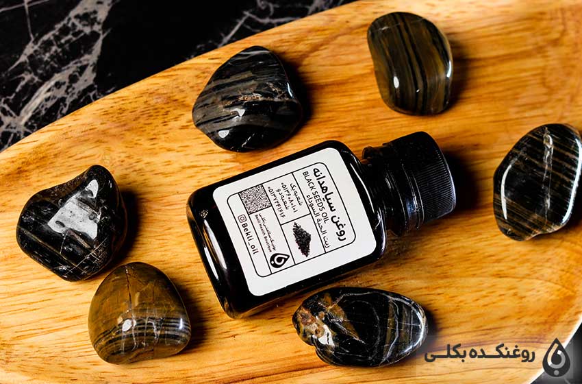 یک شیشه حاوی روغن سیاه دانه و شش عدد سنگ