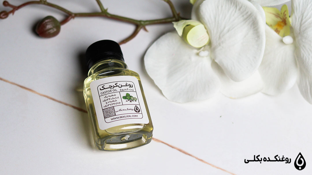 ظرف روغن کرچک در کنار یکعدد گل