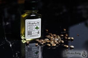 یک شیشه حاوی روغن کرچک و دانه های کرچک