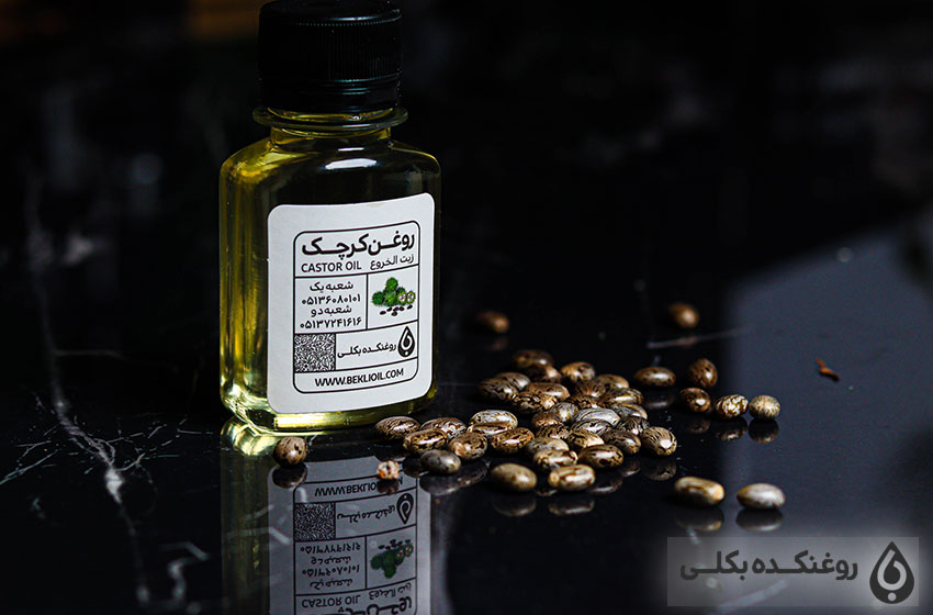 یک شیشه حاوی روغن کرچک و دانه های کرچک
