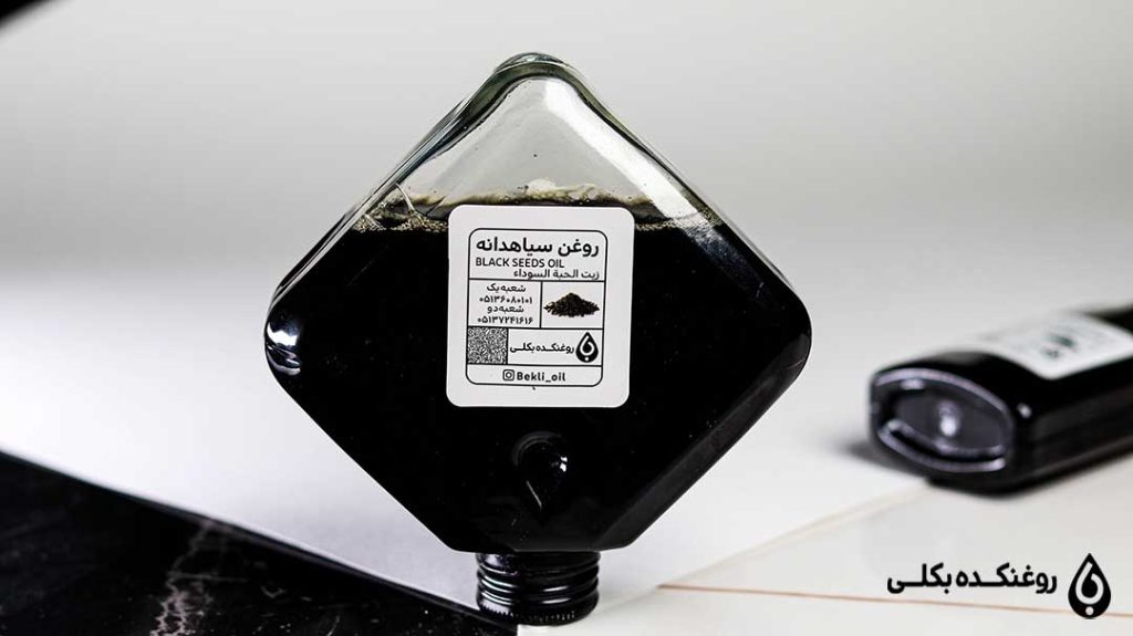 شیشه روغن سیاه دانه برعکس گذاشته شده روی میز