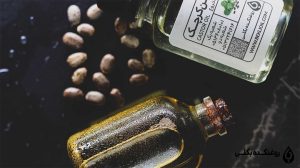 دو شیشه حاوی روغن کرچک و دانه های کرچک