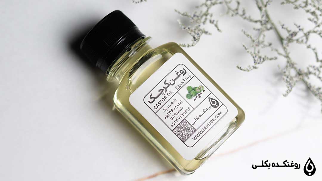 شیشه روغن کرچک در کنار چند شاخه گیاه