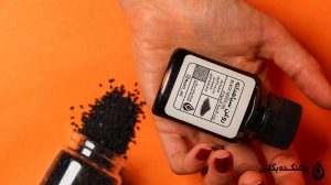روغن سیاه دانه در کنار مقداری سیاه دانه