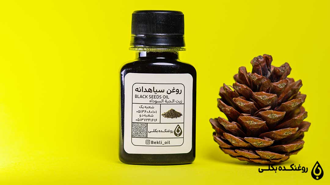 روغن-سیاهدانه در کنار میوه درخت کاج