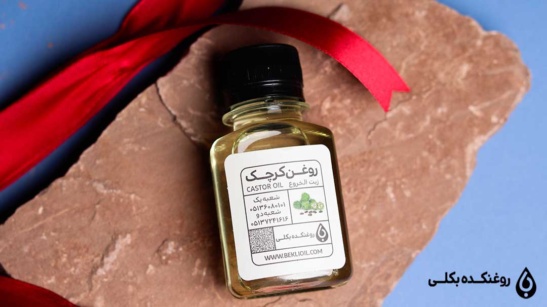 روغن کرچک در بطری بر روی سنگ