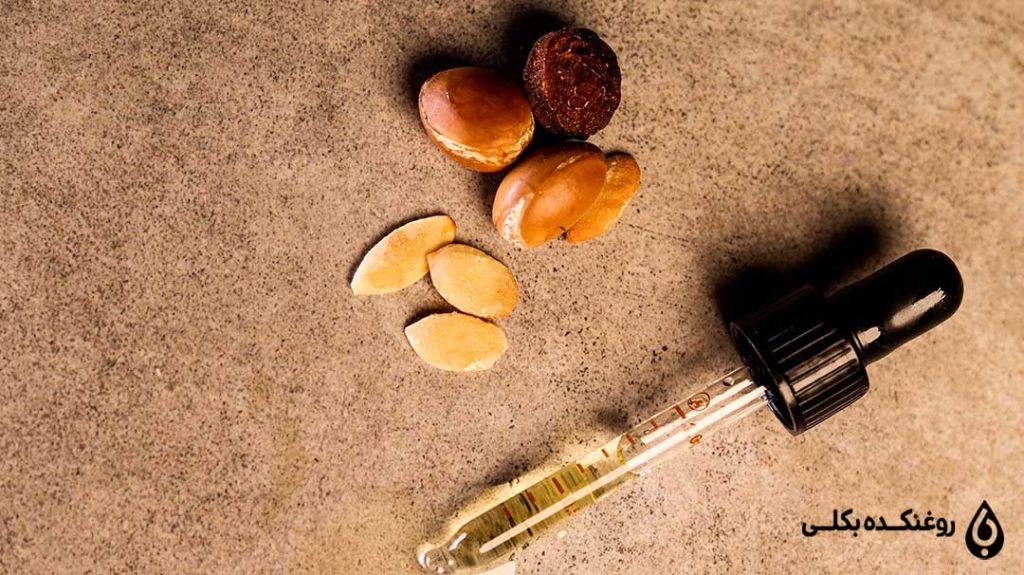 روغن آرگان در قطره چکان در کنار دانه های آرگان