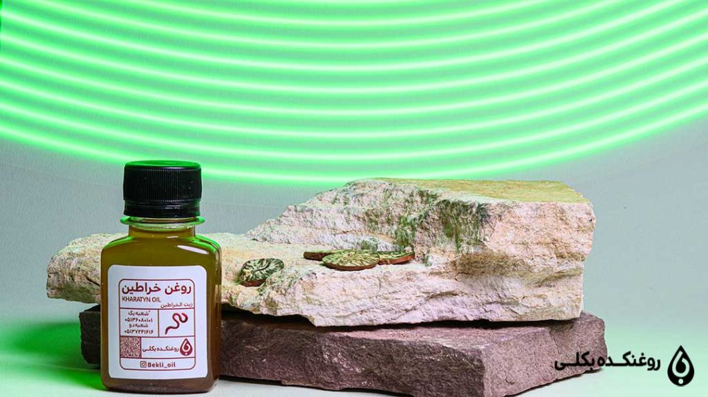 یک شیشه روغن خراطین کنار سنگ