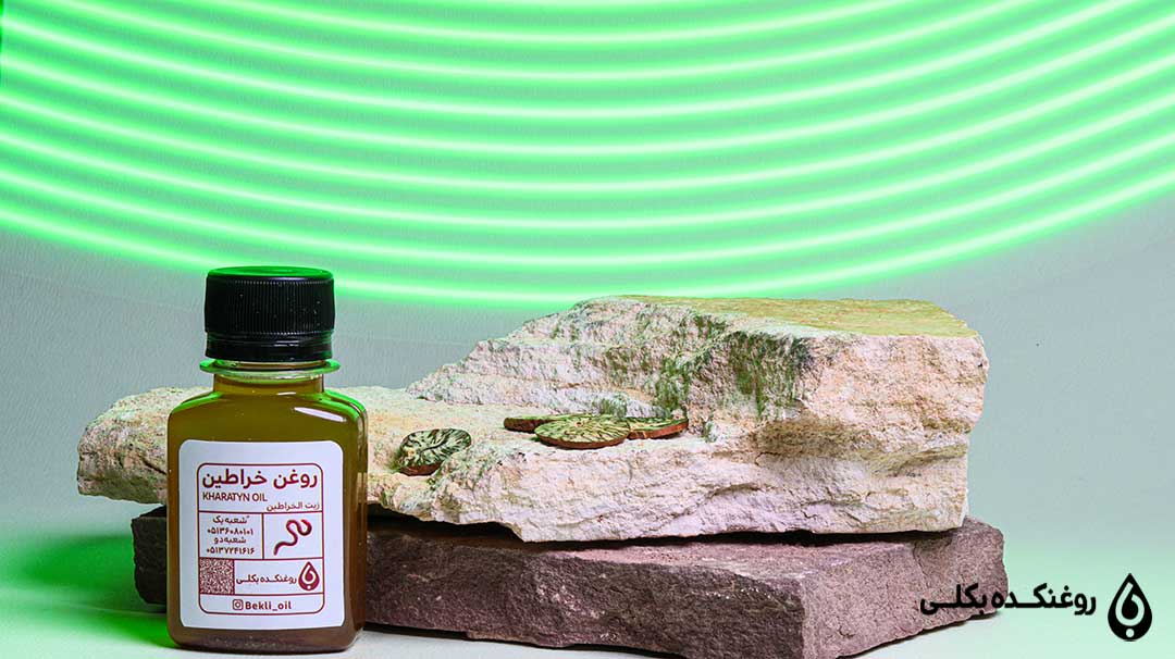 یک شیشه روغن خراطین کنار سنگ