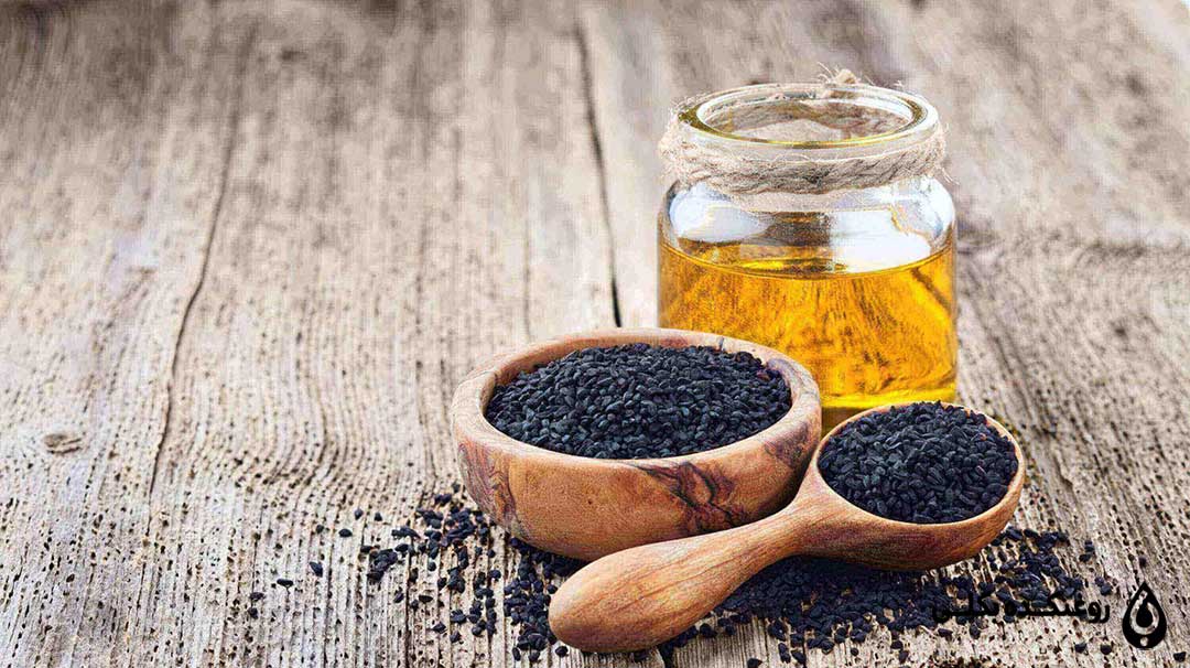 روغن سیاه دانه در کنار یک پیاله سیاه دانه