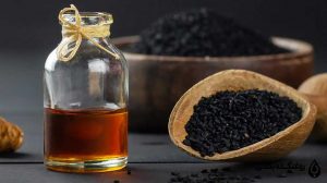 روغن سیاه دانه در کنار یک پیمانه سیاه دانه