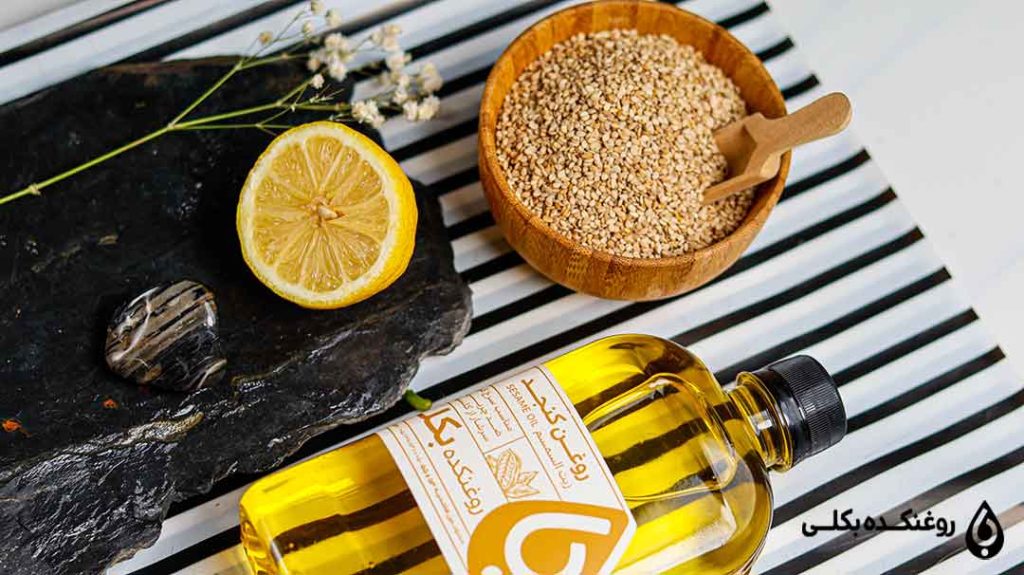 روغن کنجد در کنار یک ظرف کنجد تازه